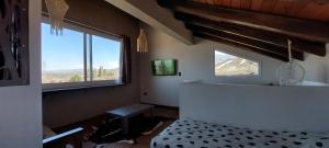 a bedroom with a bed and a large window at Ribera de Cacheuta Lodge in Las Compuertas