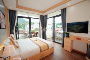 a bedroom with a large bed and a balcony at Khách sạn Kumo Chan Mộc Châu in Mộc Châu