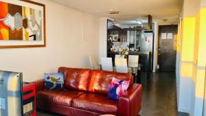 - un canapé en cuir brun dans le salon dans l'établissement Descanso frente al mar Neohaus La Serena, à La Serena