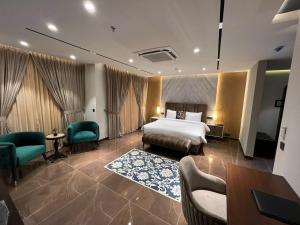 Habitación de hotel con cama, escritorio y sillas en Jacaranda Heights en Islamabad