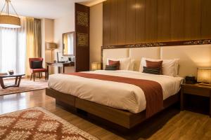 Habitación de hotel con cama grande y escritorio. en Norkhil Boutique Hotel & Spa en Thimphu