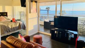 - un salon avec une télévision à écran plat et un lit dans l'établissement Descanso frente al mar Neohaus La Serena, à La Serena