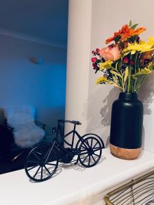 a black bike sitting next to a vase with flowers at Riverside Private Room TowerBridge in London