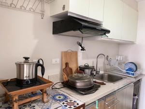 a kitchen with two pots and pans on a stove at Family-Friendly Condo with Pool, Gym, Daycare! in Bacolod