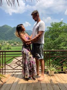a man and a woman standing on a deck at Green Homestay Mai Chau in Mai Châu