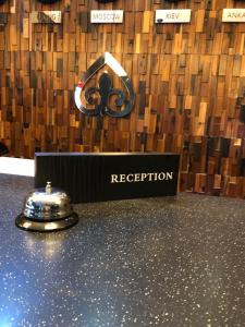 a reception counter with a bell on top of it at East Astana Hotel in Astana