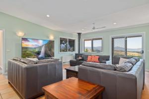 a living room with two couches and a table at Mountain Lowry Lodge in Jindabyne