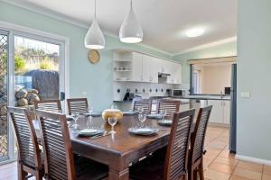 a kitchen and dining room with a wooden table and chairs at Mountain Lowry Lodge in Jindabyne