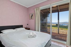 a bedroom with a bed with white shoes on it at Mountain Lowry Lodge in Jindabyne