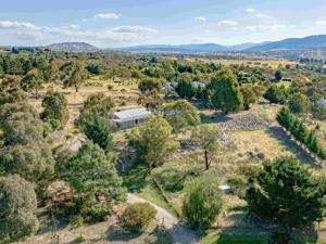 an aerial view of a house in a field with trees at Mountain Lowry Lodge in Jindabyne