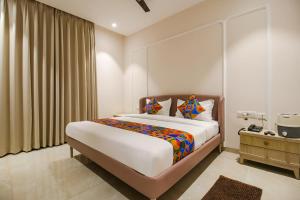 A bed or beds in a room at FabHotel Sharma & Vishnu Garden