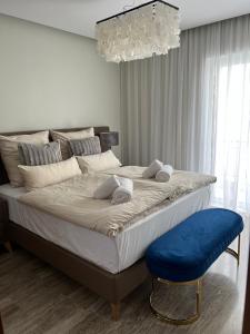 - une chambre avec un grand lit et un tabouret bleu dans l'établissement Exzellent ApartAthens 120qm, near Metro M2, à Athènes