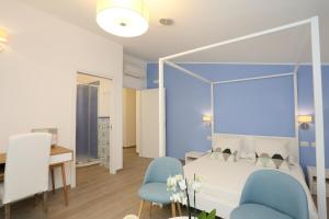 1 dormitorio con 1 cama y 2 sillas azules en Bed and Breakfast Country Cottage, en Civitavecchia