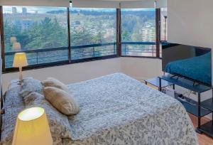 sypialnia z łóżkiem i dużym oknem w obiekcie Departamento Jardin del Mar w mieście Viña del Mar