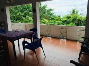 a room with a table and chairs and a balcony at Boomerang Una With Free Scooter Bike in Unawatuna