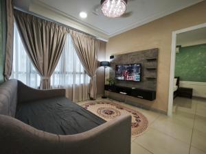 a living room with a couch and a tv at Solstice Cyberjaya by Idealhub in Cyberjaya