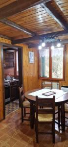 a dining room with a table and chairs and a kitchen at Casa Sofia in Pamparato