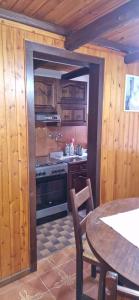 a kitchen with a stove and a table in a room at Casa Sofia in Pamparato
