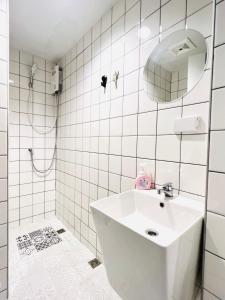 uma casa de banho branca com um lavatório e um espelho em El biógrafo em Bangkok
