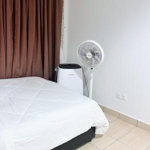 - une chambre avec un lit blanc et un ventilateur dans l'établissement Modern Cozy Home with Minimalist design, à Tuaran