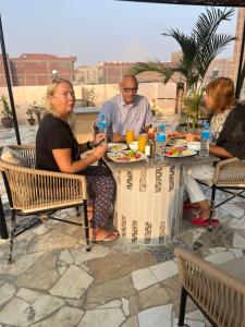 a group of people sitting at a table eating food at King Badr Pyramids Inn in Cairo