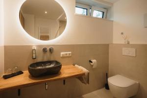baño con lavabo negro y espejo en Boutique Hotel Haus Marie en Gerabronn