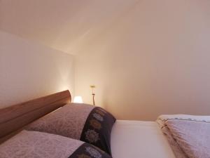 - une petite chambre avec deux lits et une lampe dans l'établissement Ferienwohnung-Familie-Guenther, à Wolkenstein