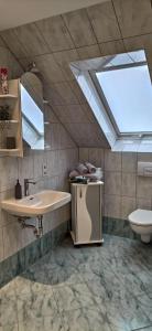 La salle de bains est pourvue d'un lavabo, de toilettes et d'une lucarne. dans l'établissement Ferienwohnung-Familie-Guenther, à Wolkenstein