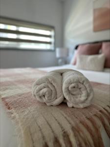 um animal de toalha está enrolado numa cama em 2 On Trend Condo Near Crown 1br em Perth