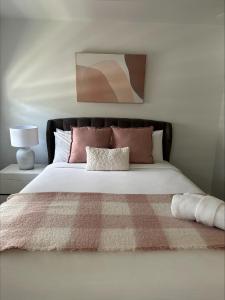 um quarto com uma cama grande e almofadas cor-de-rosa em 2 On Trend Condo Near Crown 1br em Perth