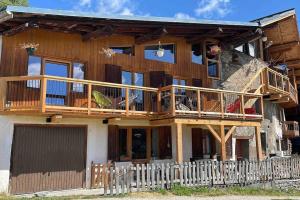 a large wooden house with a large deck at Chalet au cœur de la haute Tarentaise in Séez