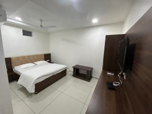 a bedroom with a bed and a flat screen tv at Hotel Sagar in Dewās