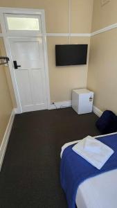 a room with a bed and a door and a television at Lambton Park Hotel in Lambton