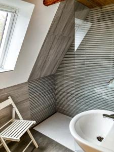 uma casa de banho com uma cadeira e uma banheira em LIETHE 13 - Ferienhaus am Malerweg em Kurort Gohrisch