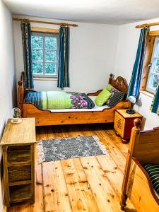 a bedroom with a bed and a wooden floor at LIETHE 13 - Ferienhaus am Malerweg in Kurort Gohrisch