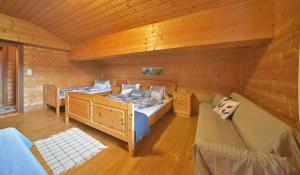 a bedroom with two beds in a log cabin at RANGERSDORFER HÜTTE in Witschdorf