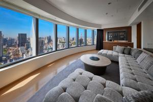 a living room with a couch and a large window at Park Hotel Tokyo in Tokyo