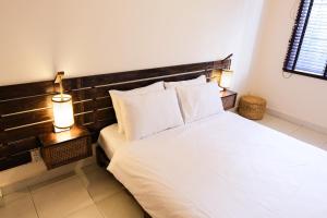 a bedroom with a white bed with a wooden headboard at Mao Home in Ho Chi Minh City