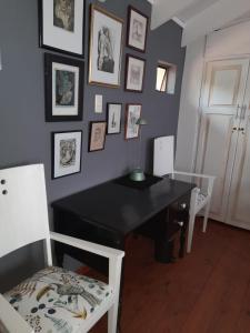 Habitación con mesa negra y 2 sillas blancas. en Gadute Haven, en Pretoria