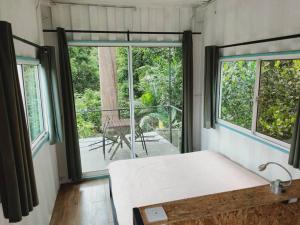 a bedroom with a bed and a large window at Sarang by the brook in Kuala Kubu Baharu