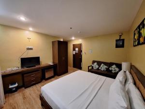 ロハスにあるAlunsina Hotel and Spaのベッドルーム(大型ベッド1台、ソファ付)
