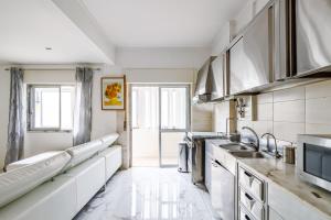 eine Küche mit weißen Geräten und einem großen Fenster in der Unterkunft Moreira in Amora