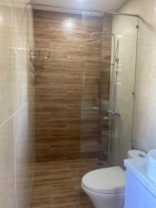 a bathroom with a toilet and a glass shower at Tree Homestay in Da Nang