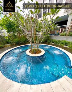 uma árvore sentada em cima de uma piscina azul em Bukit Bintang Brand new luxury skypool by LuxeHost em Kuala Lumpur