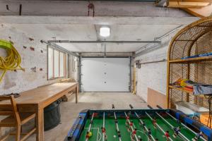 eine Garage mit Billardtisch und Garagentor in der Unterkunft Gezellige villa aan zee met ruim terras voor 6p in De Panne