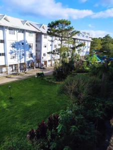 Un patio verde con edificios al fondo. en Green Valley Condo with View, en Baguio