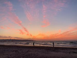 two people standing on the beach at sunset at אירוח סמוך לים התיכון יש מקלט בבניין in Haifa
