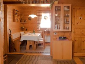 una cucina e una sala da pranzo con tavolo in una cabina di Ferienhaus Nr 15, Typ A, Feriendorf Jägerpark, Bayerischer Wald a Viechtach