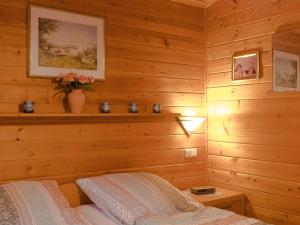 una camera con pareti in legno e un letto in una stanza di Ferienhaus Nr 15, Typ A, Feriendorf Jägerpark, Bayerischer Wald a Viechtach