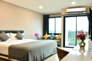 Habitación de hotel con cama y balcón en NORN Rimkhlong Bangkok นอนริมคลอง en Bangkok Noi